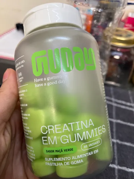 Cliente com o pote de Creatina em Gummies Guday sabor maçã verde