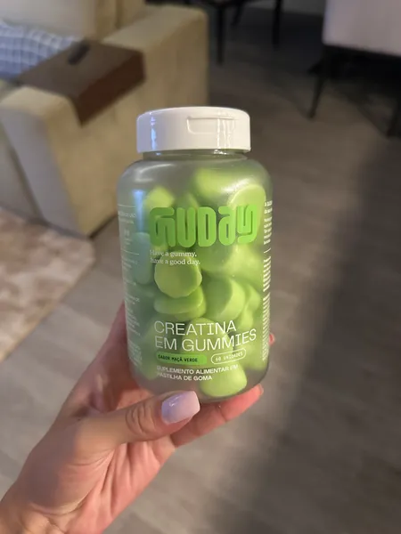 Cliente com o pote de Creatina em Gummies Guday maçã verde